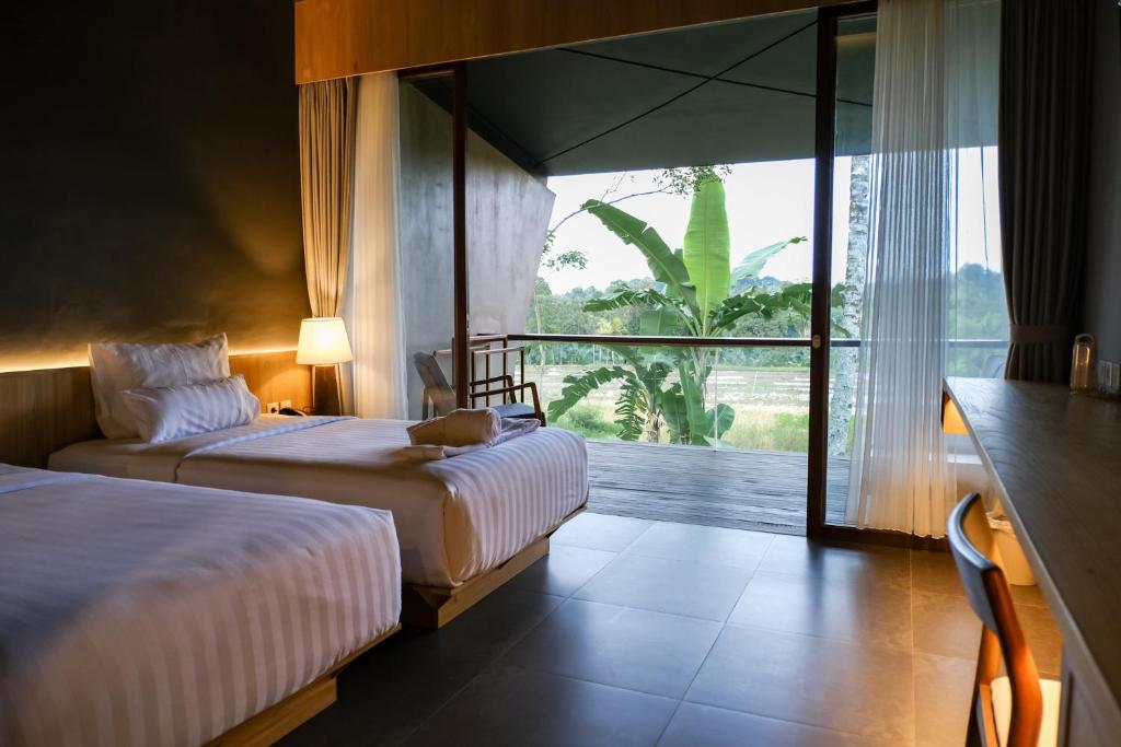 Espace extérieur avec piscine et végétation dans un hôtel de Banyuwangi.